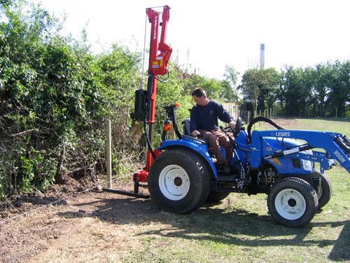 Compact Tractor with Hydraulic Post Driver Erecting Posts for Fencing